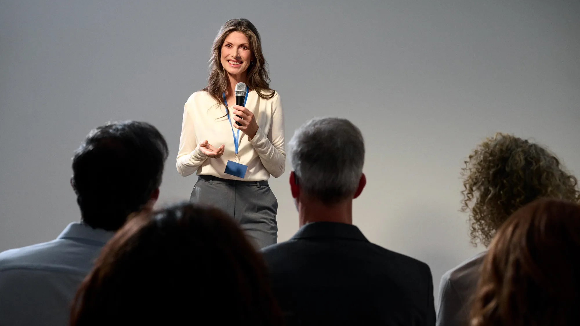 Empowered woman presenting, wearing hearing aids.