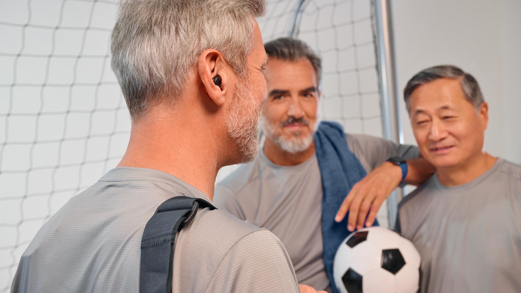 Man playing football wearing Signia Active hearing aids
