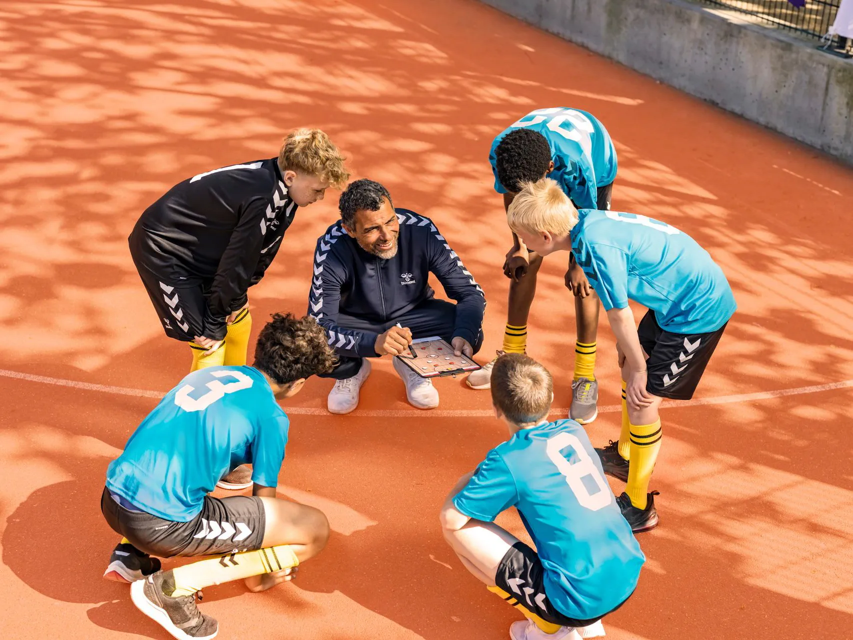 Signia IX coach going through tactics with his team wearing hearing aids. 