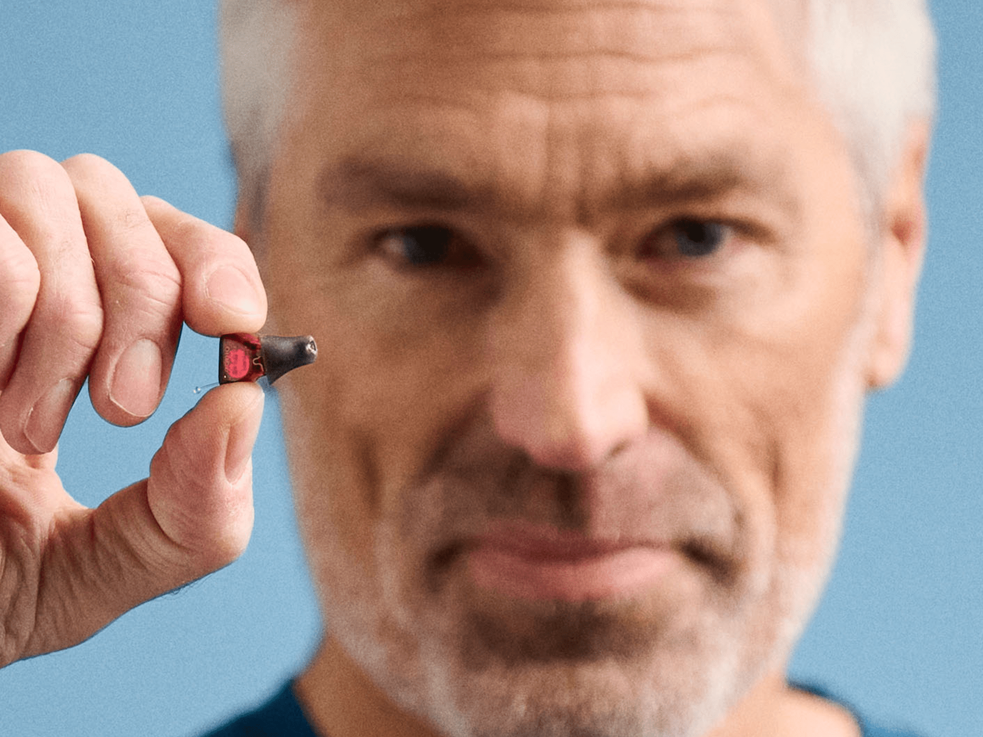 Hand holding a microchip used in hearing-aids, showcasing advanced technology for people with hearing-loss in a compact design.
