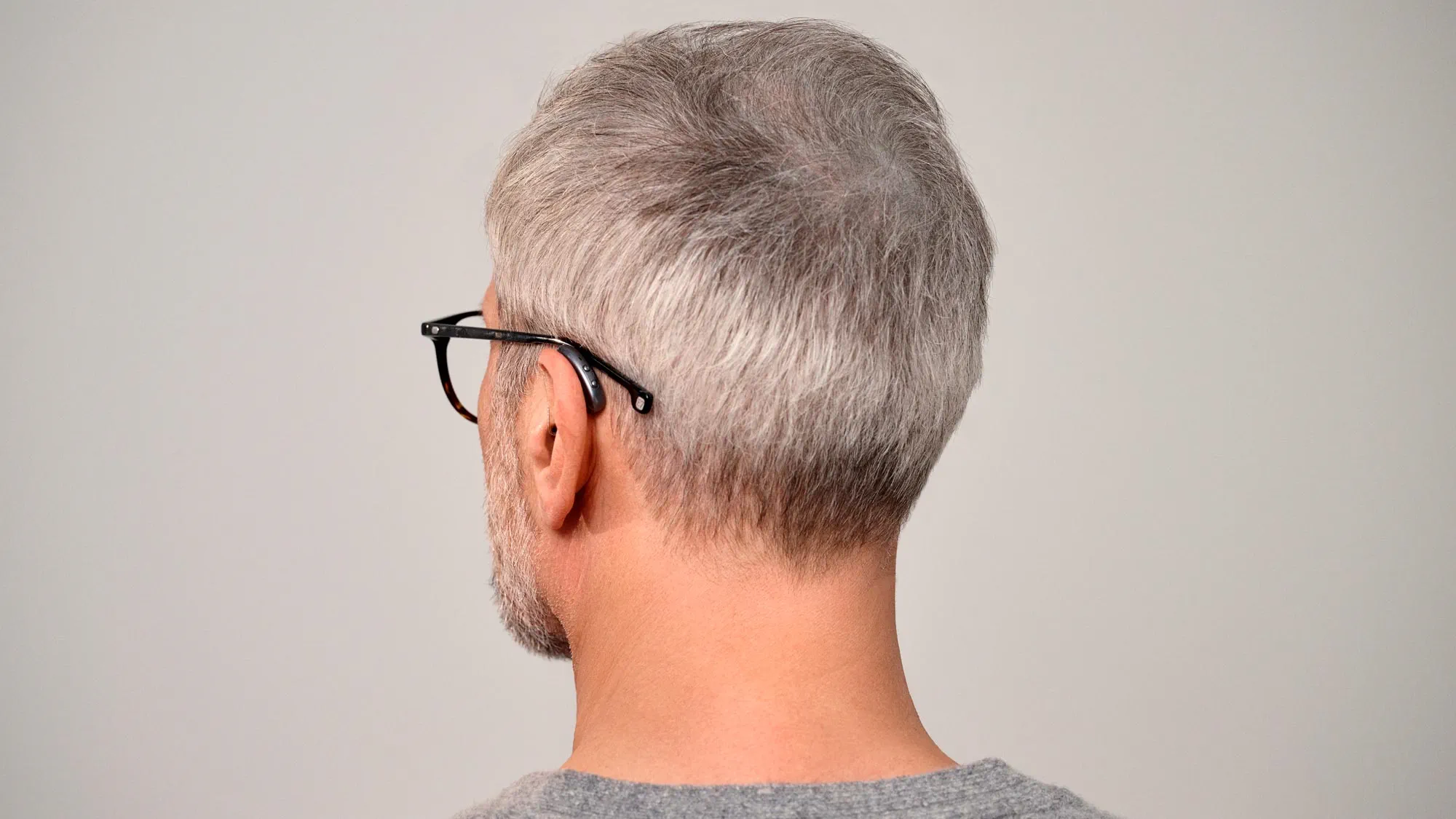 Seeing man from behind wearing Signia Pure hearing aids showing how small they are