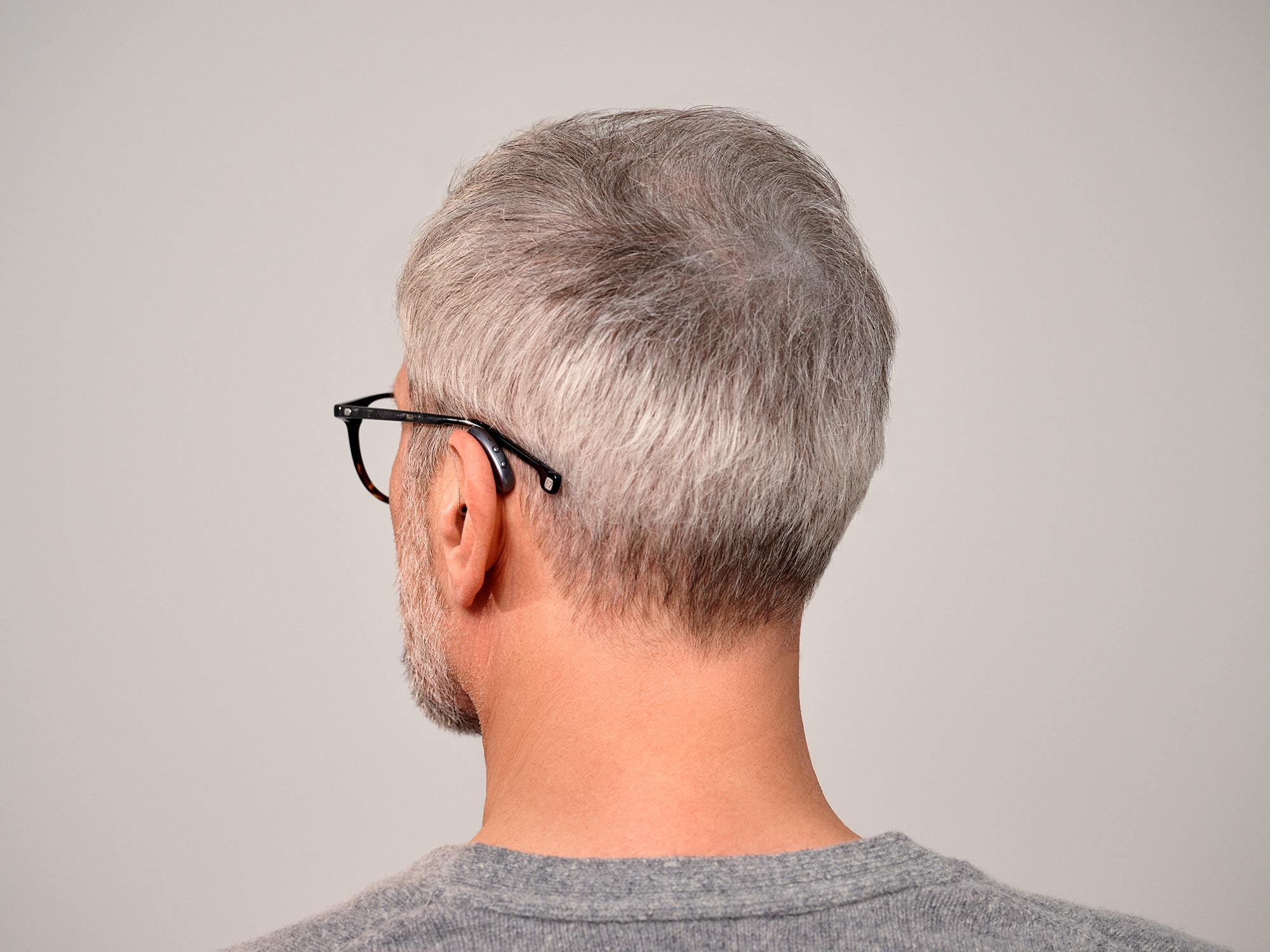 Seeing man from behind wearing Signia Pure hearing aids showing how small they are