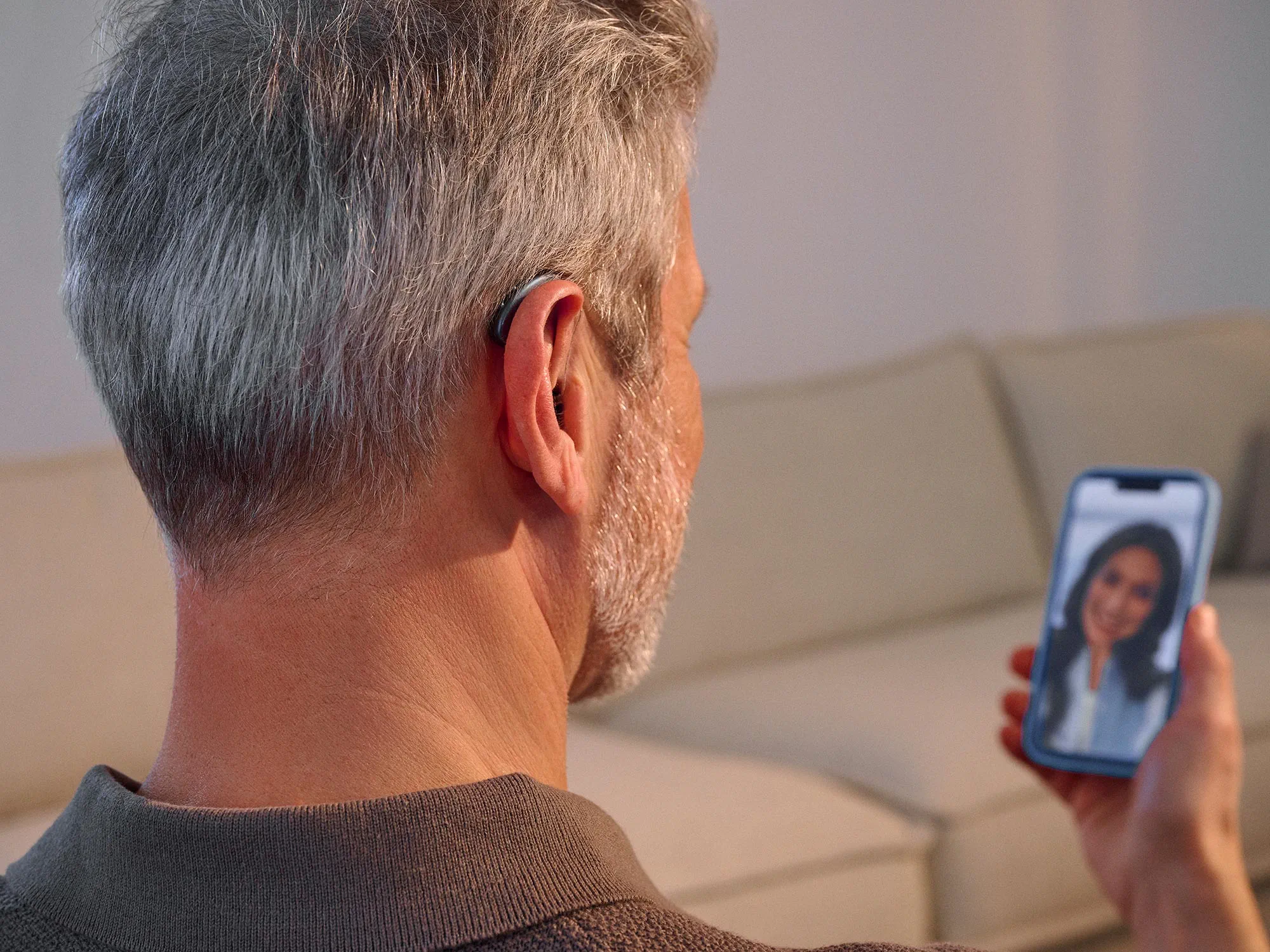 Mann, der mit Signia Pure Hörgeräten telefoniert und alle Details hört