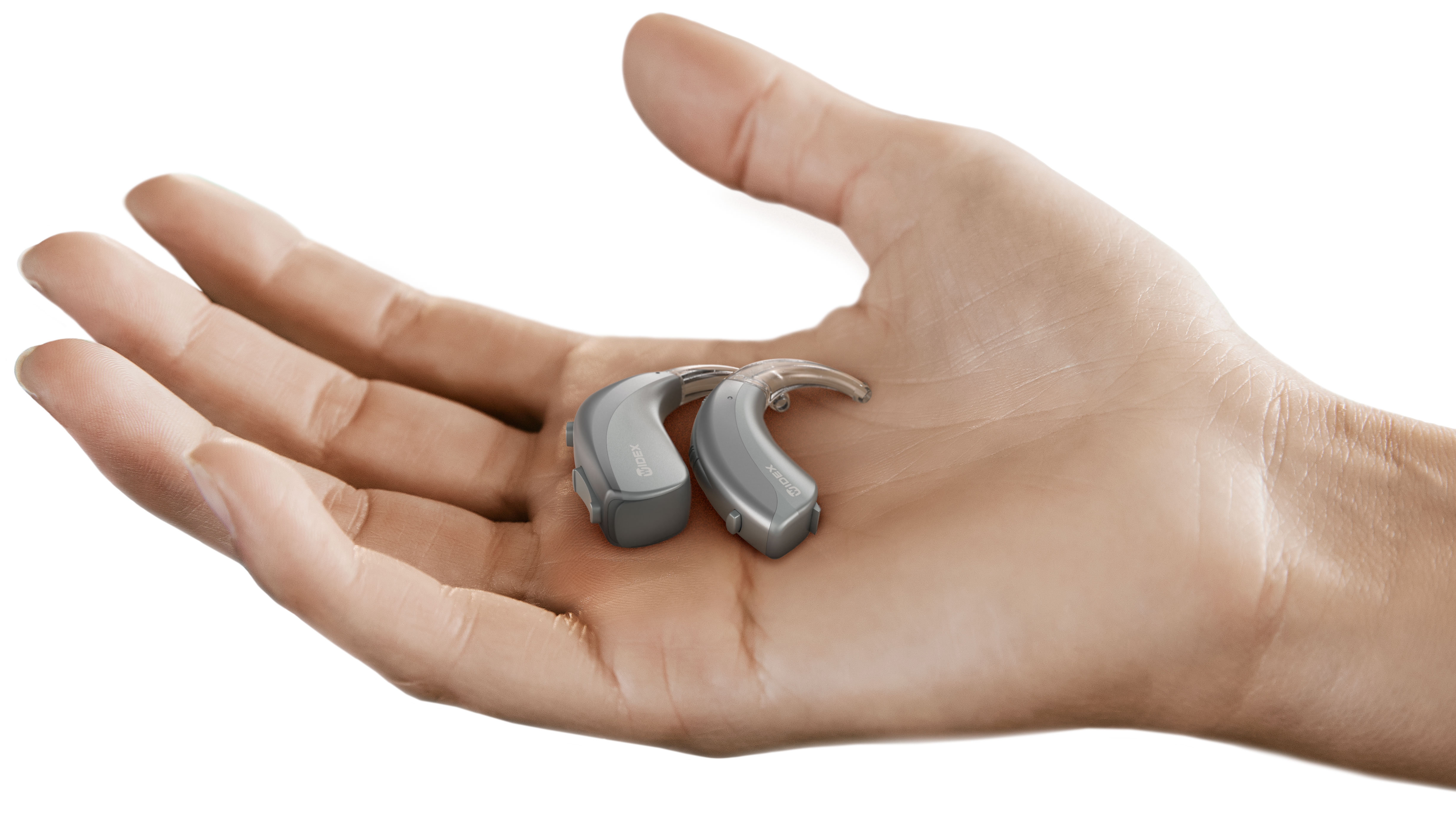 Widex Moment BTE hearing aids displayed in hand. 