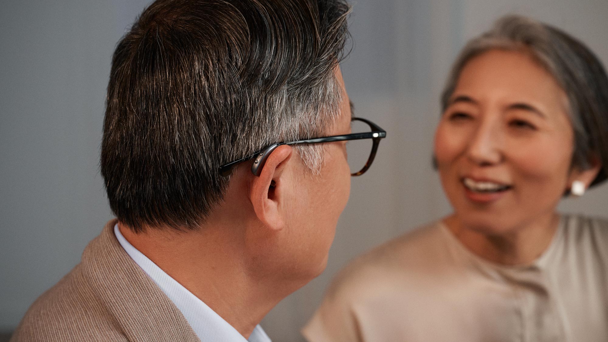 Couple chatting with man wearing Widex moment RIC hearing aids.