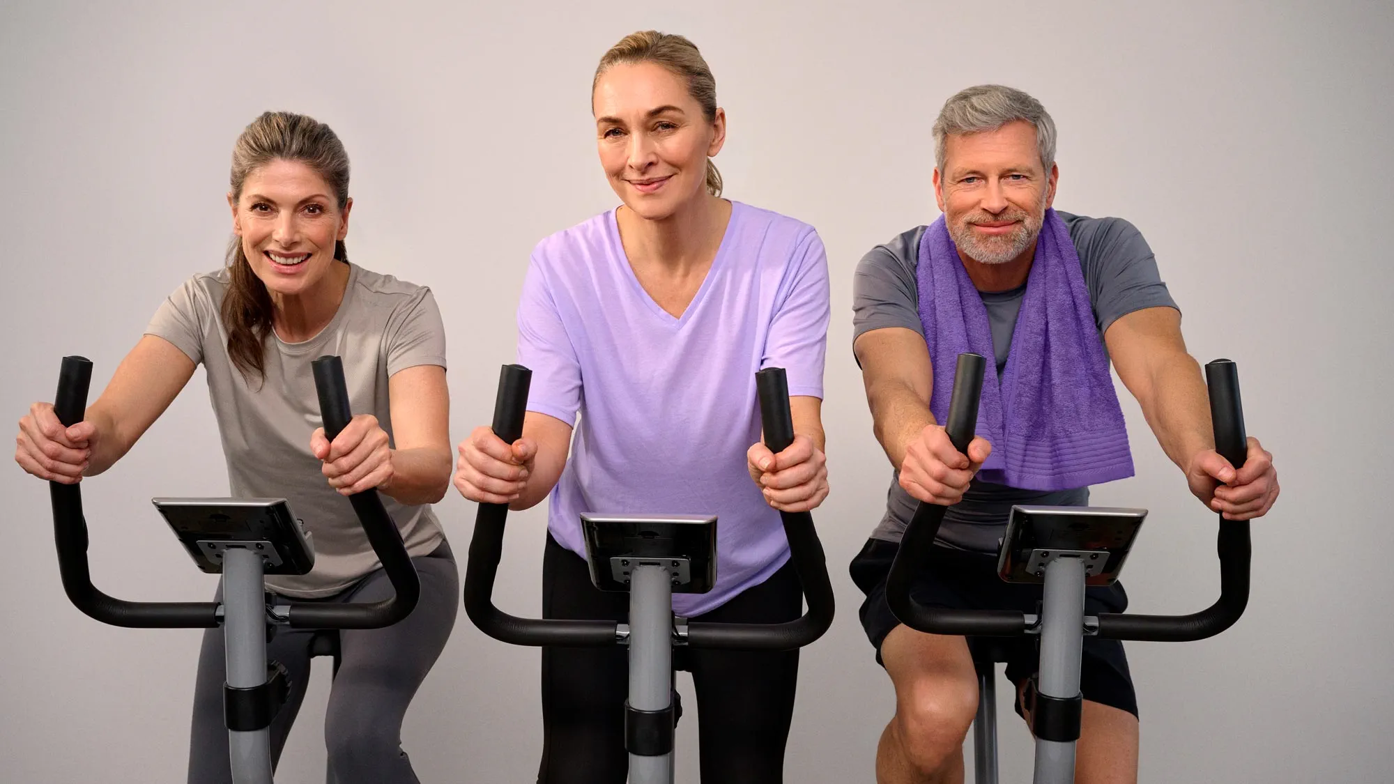 Amigos a participar de uma aula de ciclismo, a usar aparelhos auditivos.