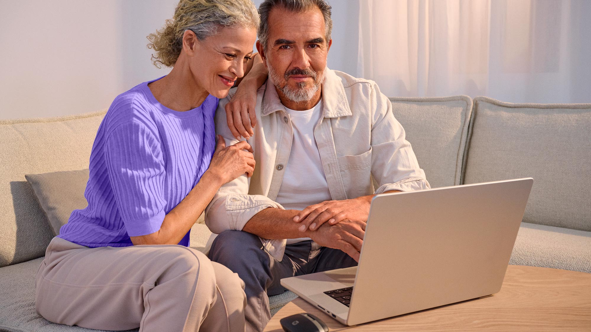 Confident couple using technology, highlighting hearing improvement.