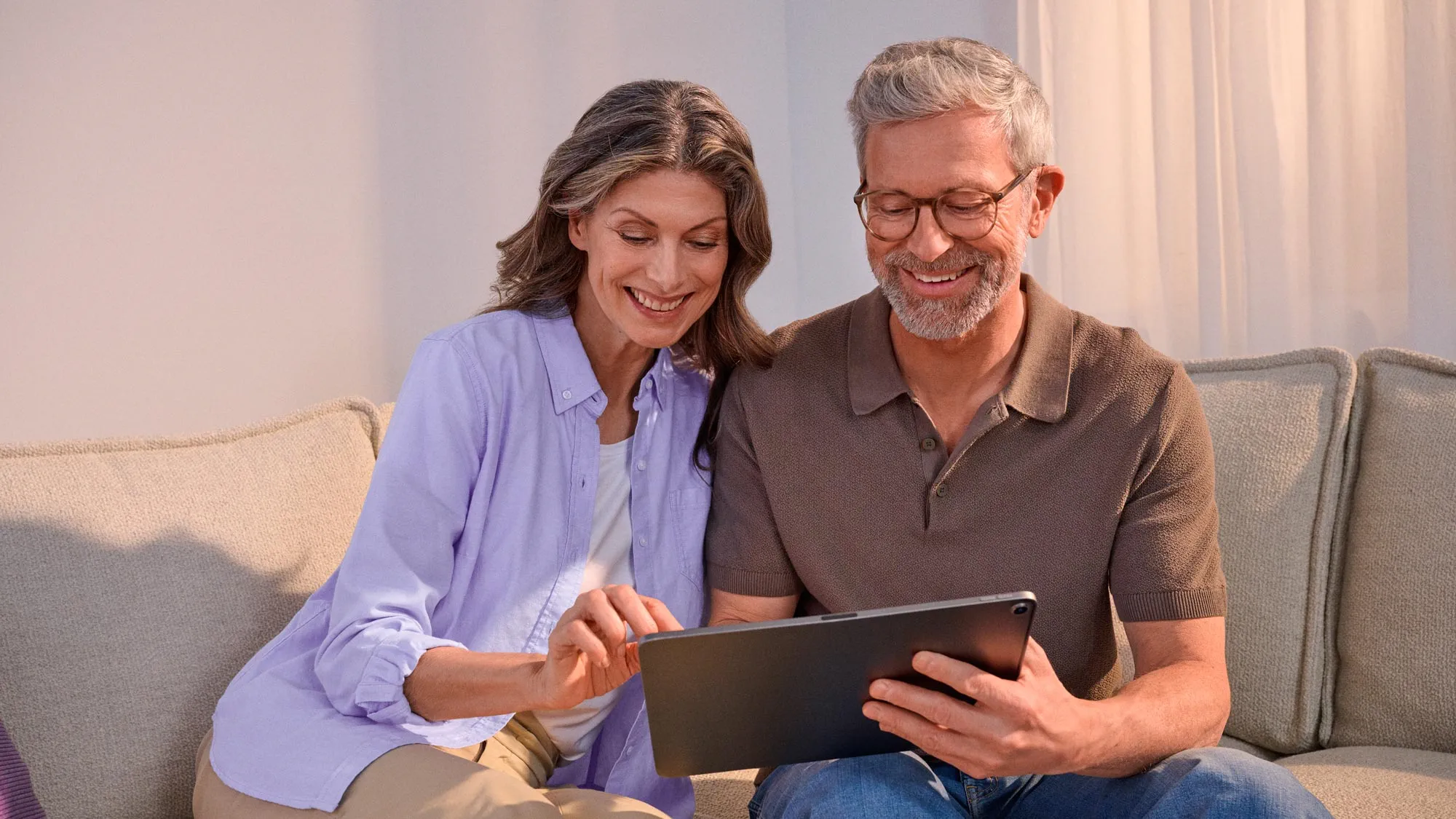 Enthusiastic couple using technology and benefiting from hearing improvement.