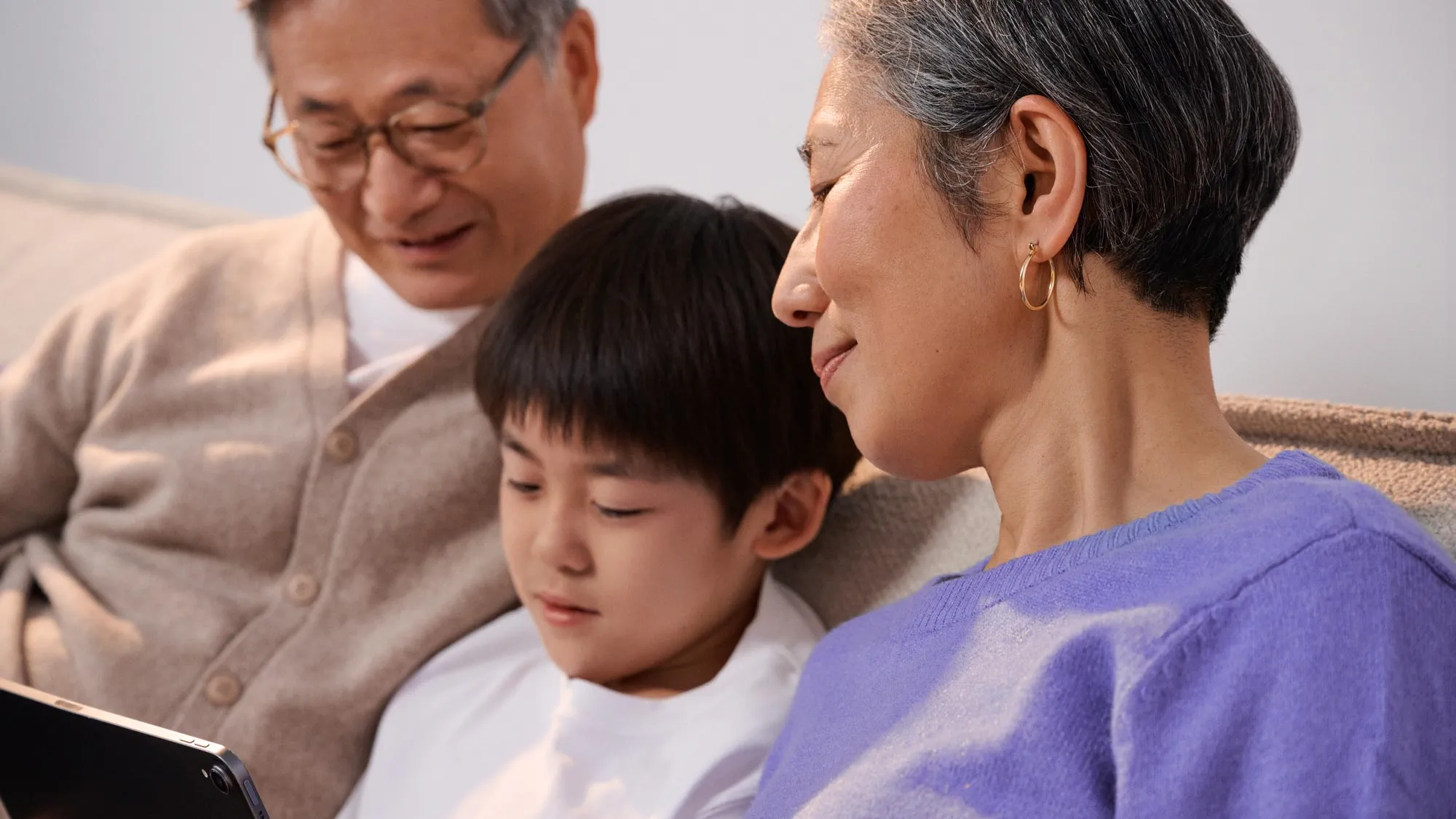 Grandparents and boy discussing technology and hearing loss.