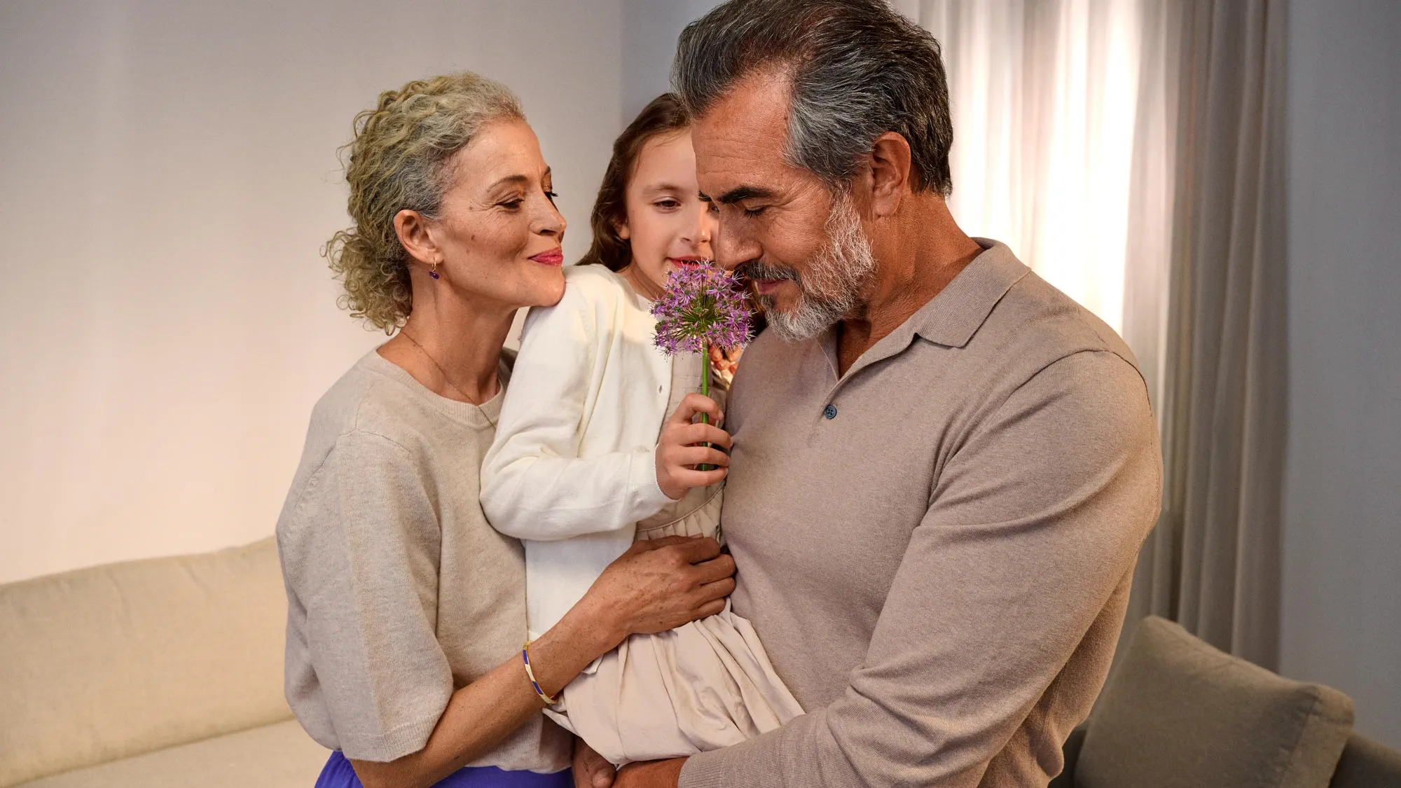 Avós a desfrutar do aroma das flores, a usar aparelhos auditivos.