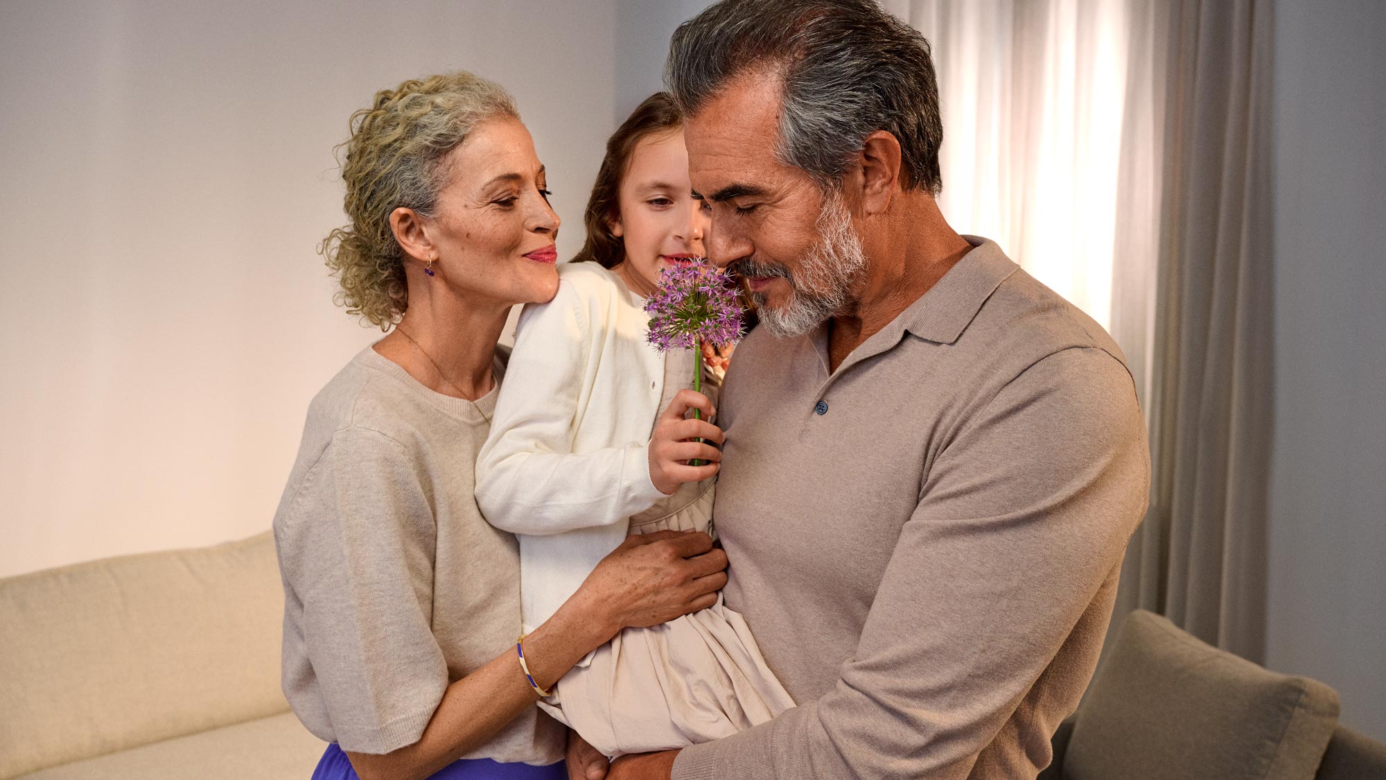 Avós a desfrutar do aroma das flores, a usar aparelhos auditivos.
