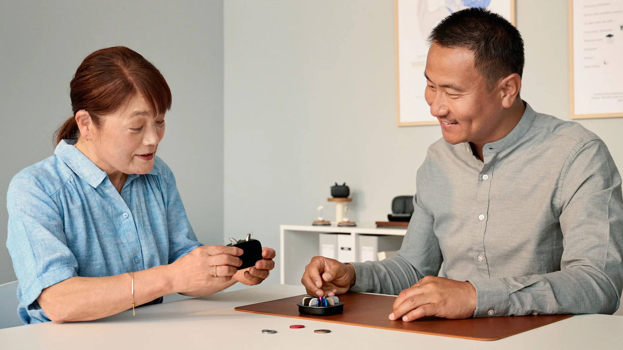 聴覚専門家と相談しながら補聴器のモデルを選択する顧客。