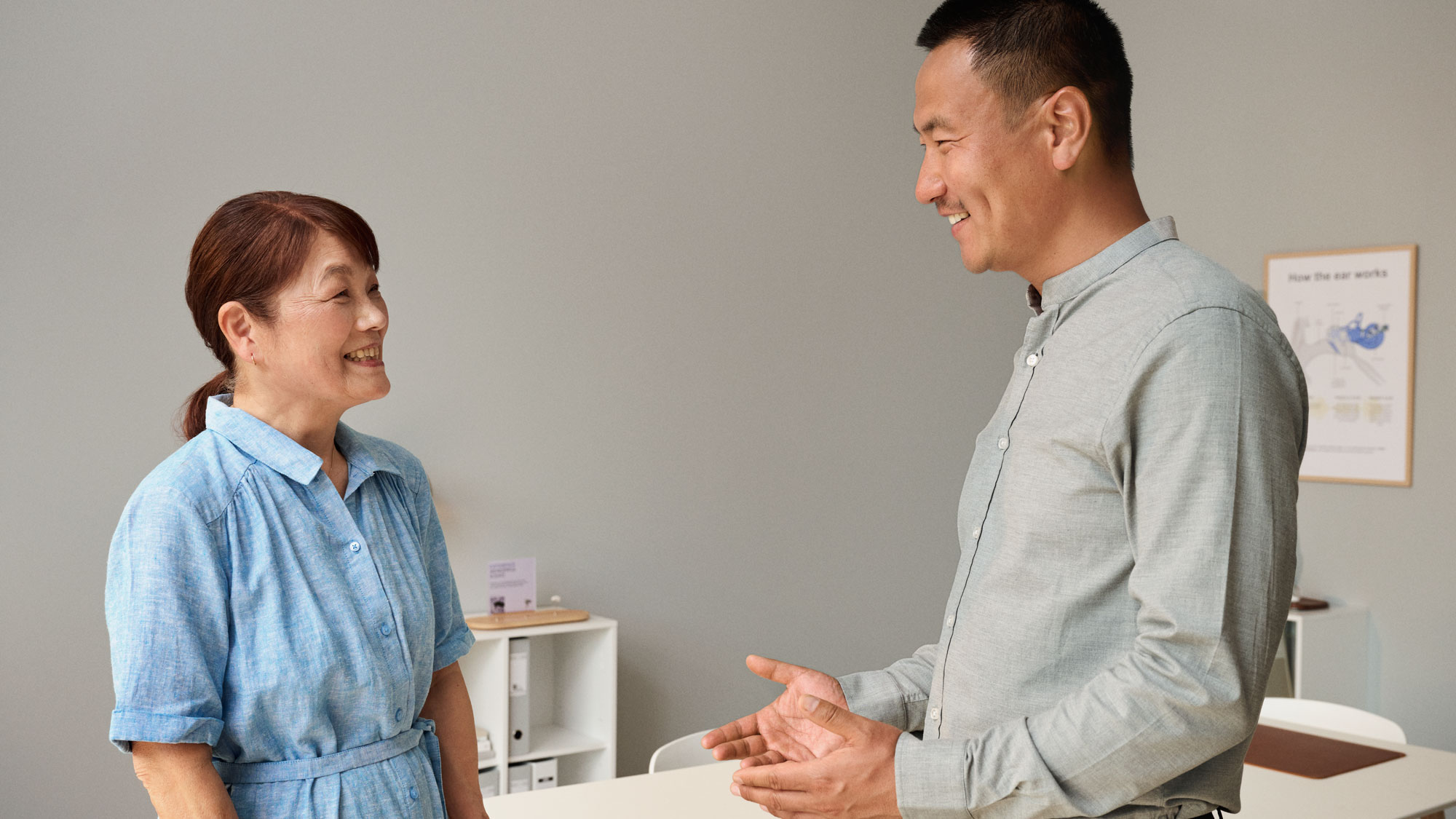 聴覚検査の予約開始時に聴覚専門医に挨拶する顧客。
