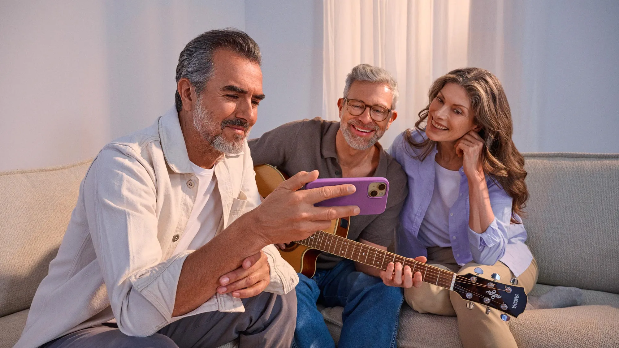 Amigos a ver algo num telefone, a celebrar a melhoria auditiva.