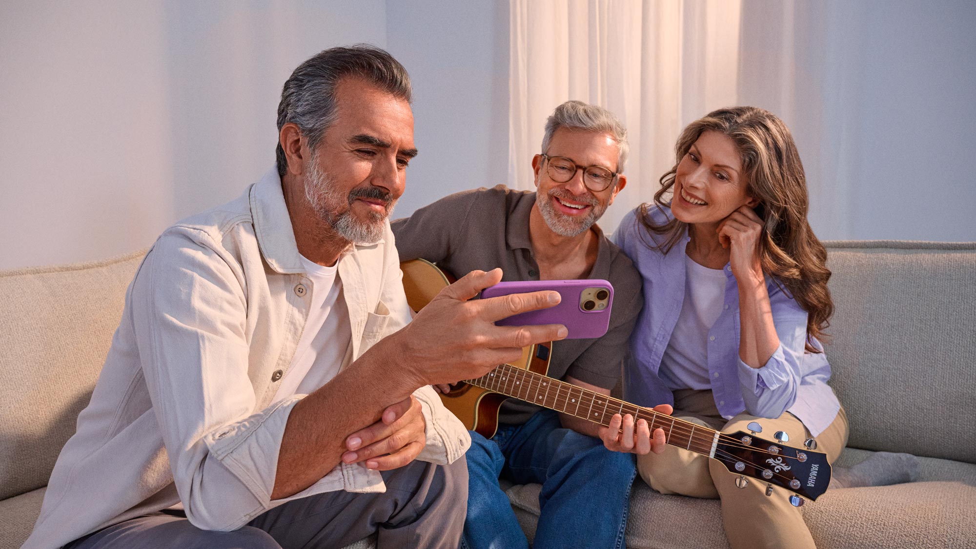 Amigos a ver algo num telefone, a celebrar a melhoria auditiva.