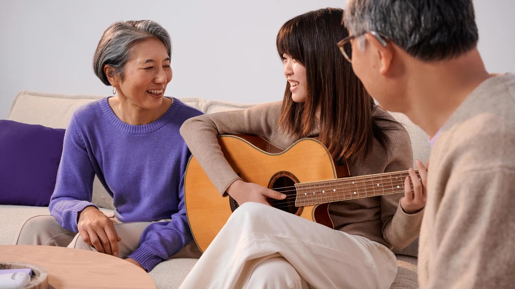若い女の子とギターと一緒にいる祖父母、補聴器が見えている。