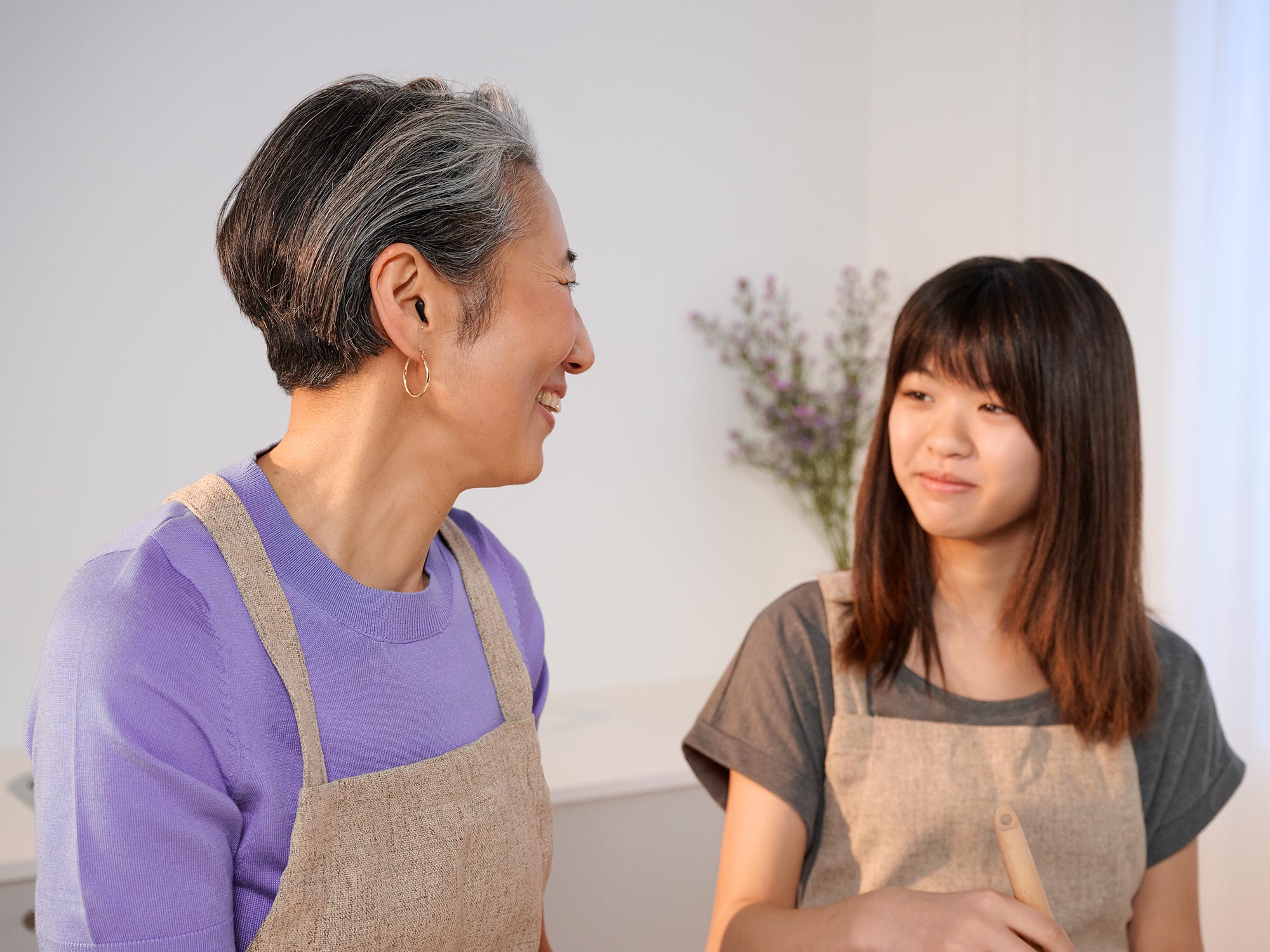 補聴器を装着しながら料理をしているおばあさんのクローズアップ。