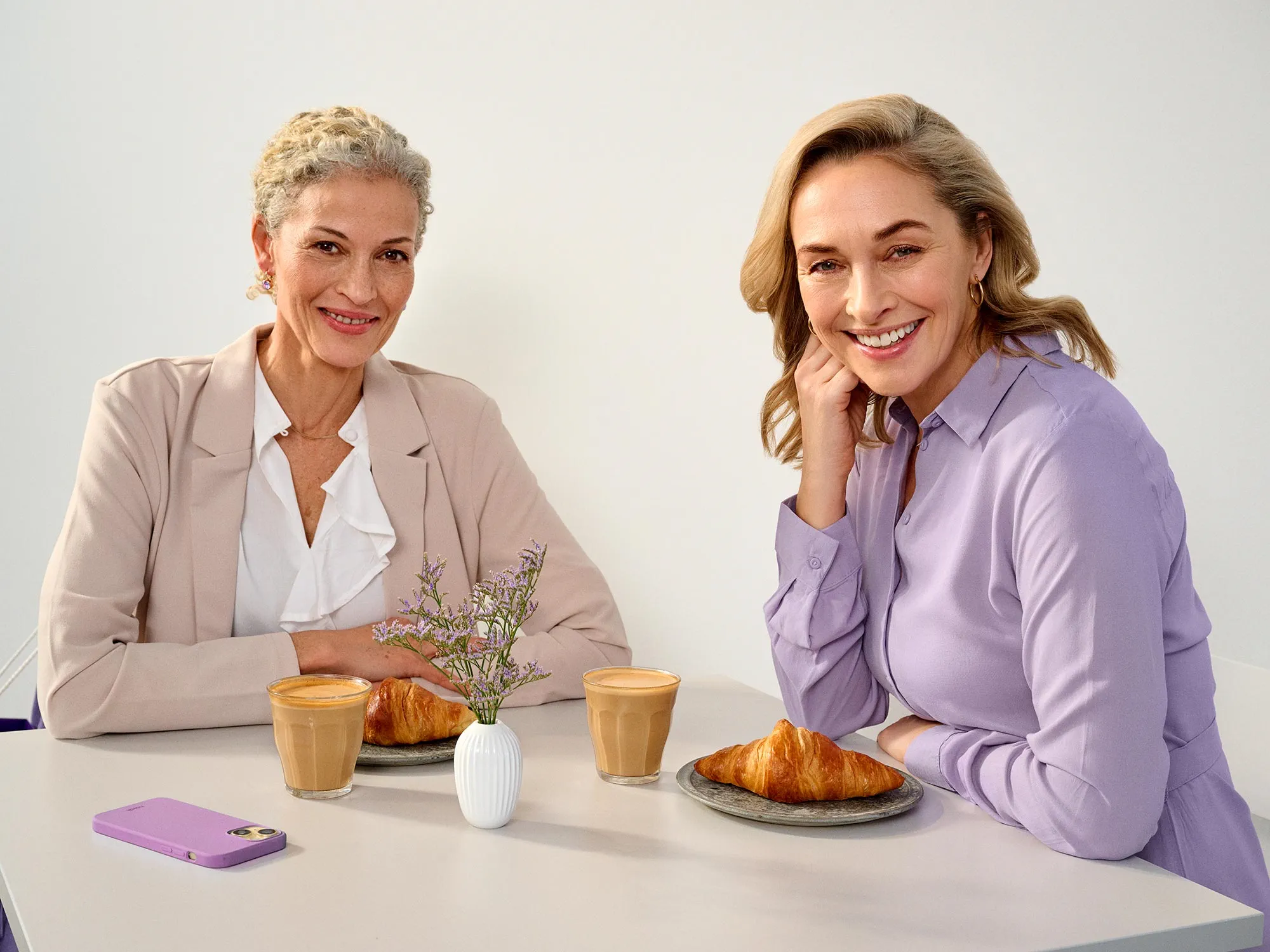 Friends enjoying time at a cafe, wearing hearing aids.
