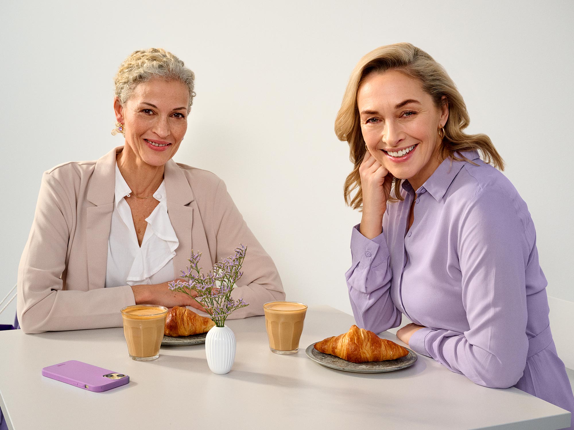 Friends enjoying time at a cafe, wearing hearing aids.