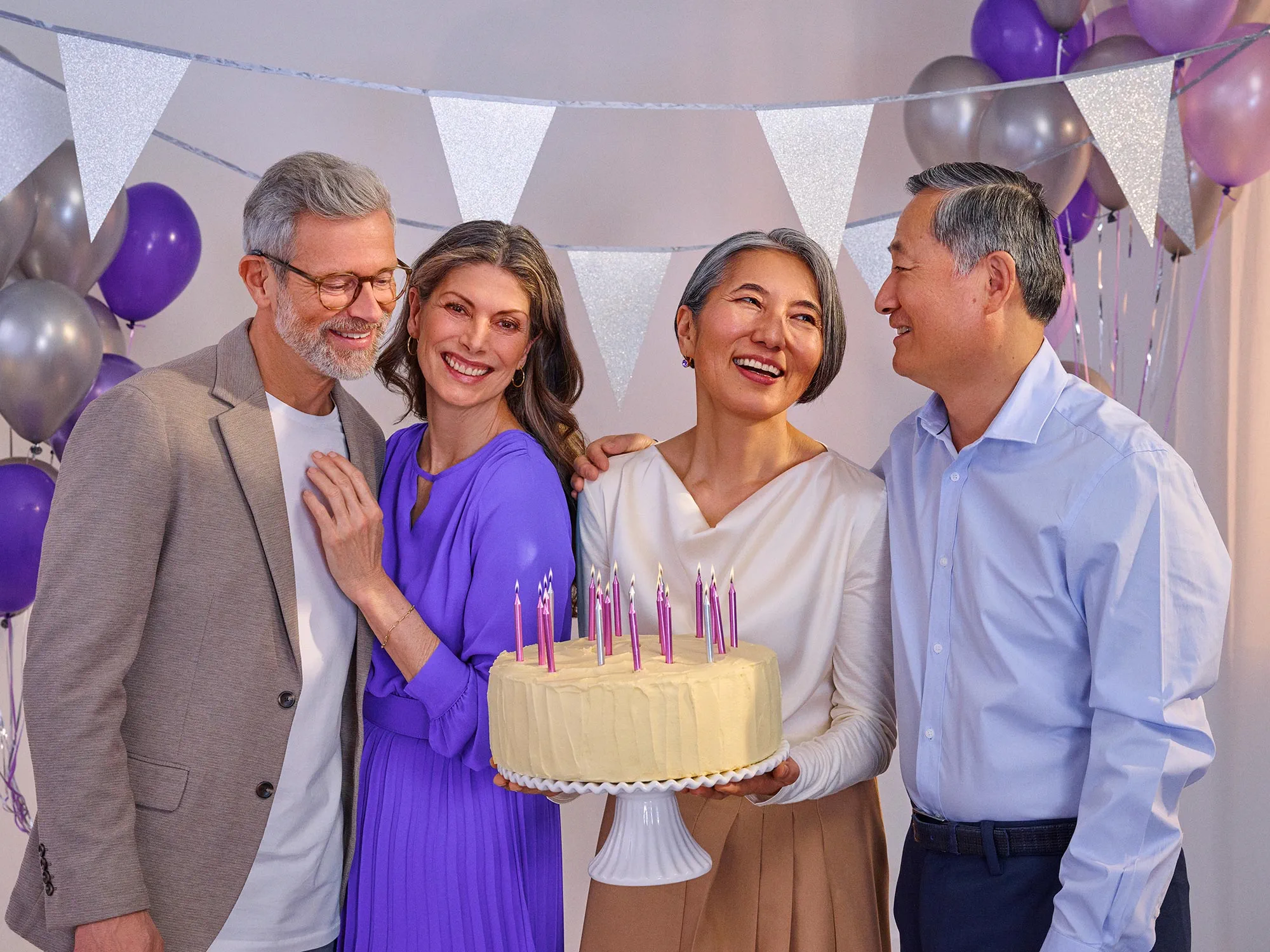 Friends glancing at each other during a birthday, indicating hearing improvement.
