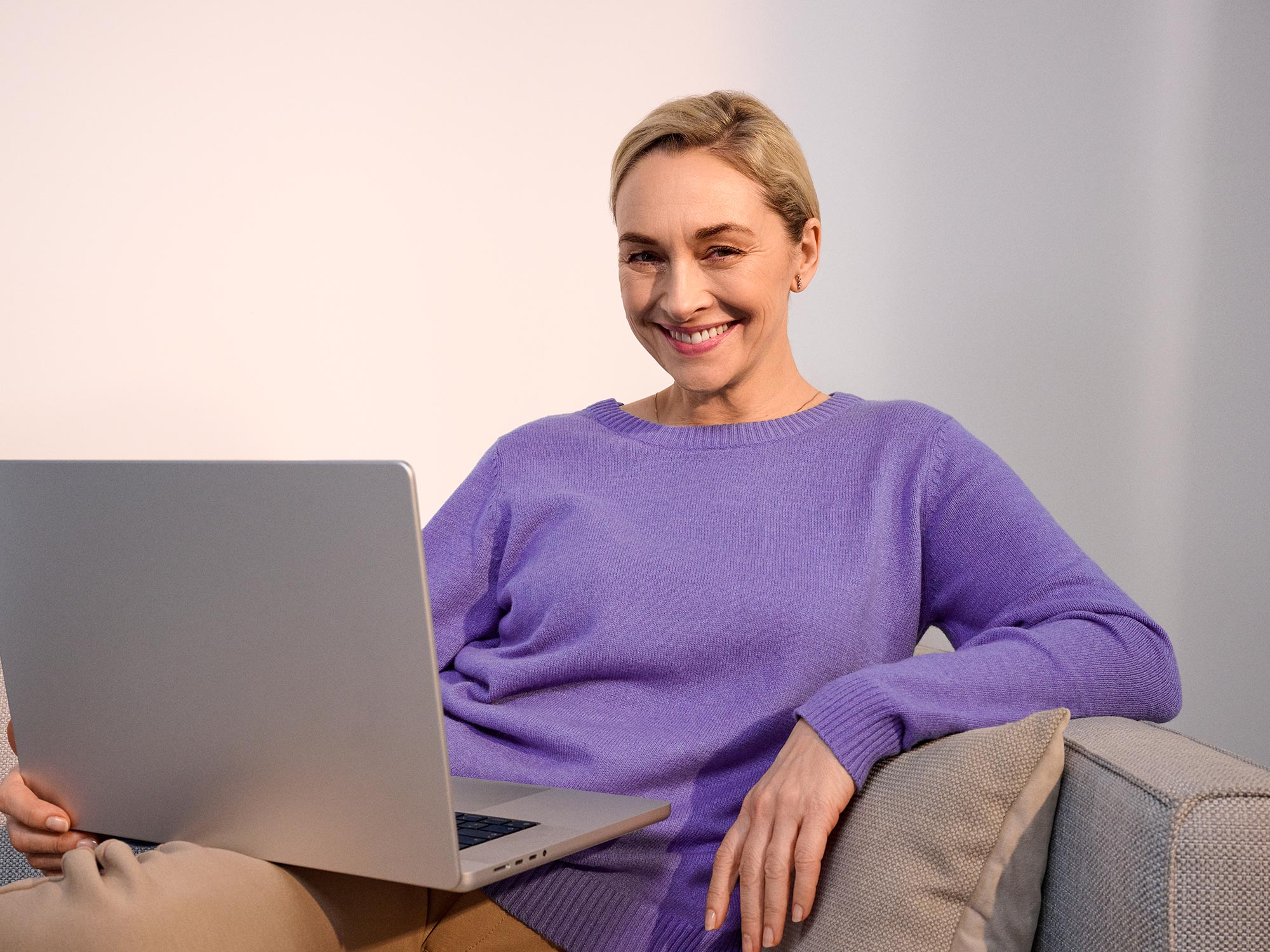 Happy woman using a computer, wearing hearing aids.
