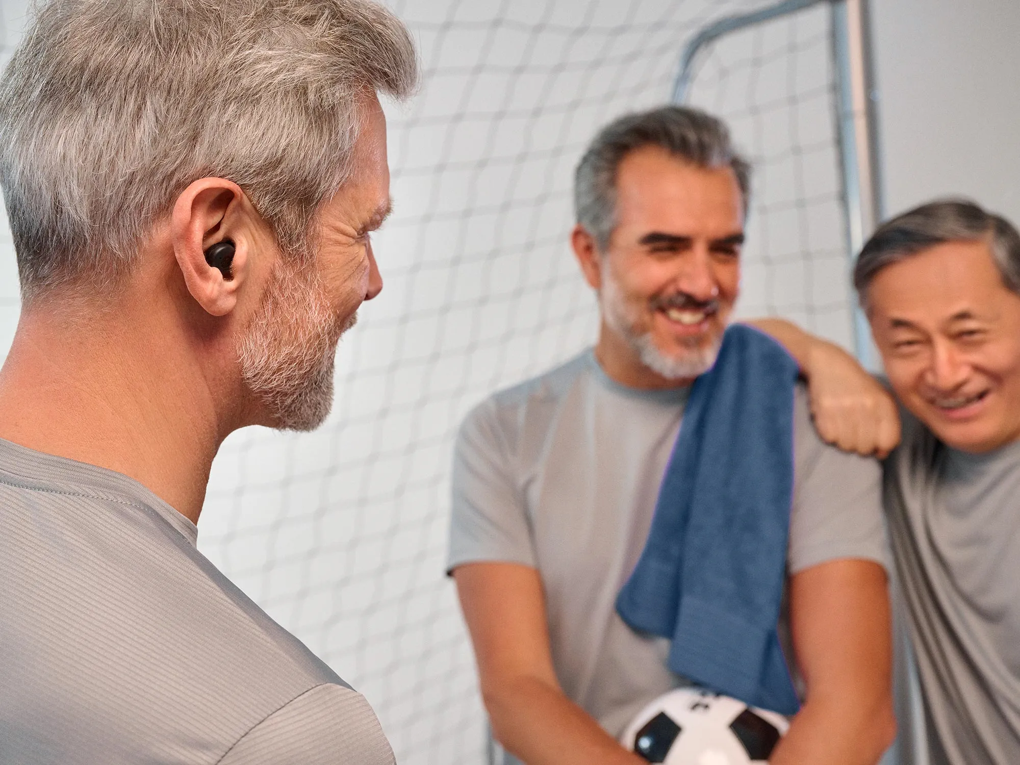 周囲の音を聞きながらシグニア アクティブ補聴器を装着してサッカーをする男性