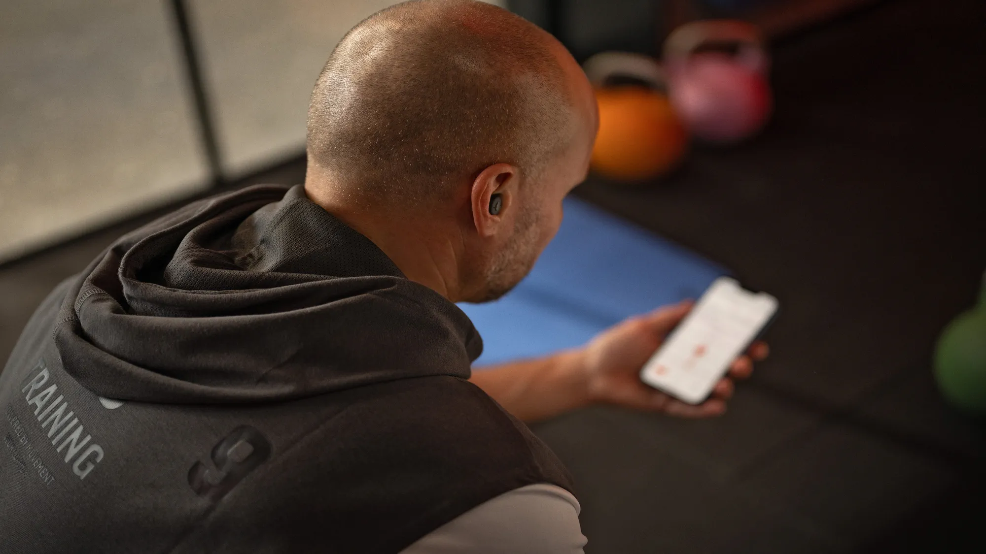 補聴器を装用しスマートフォンでストリーミング中の男性