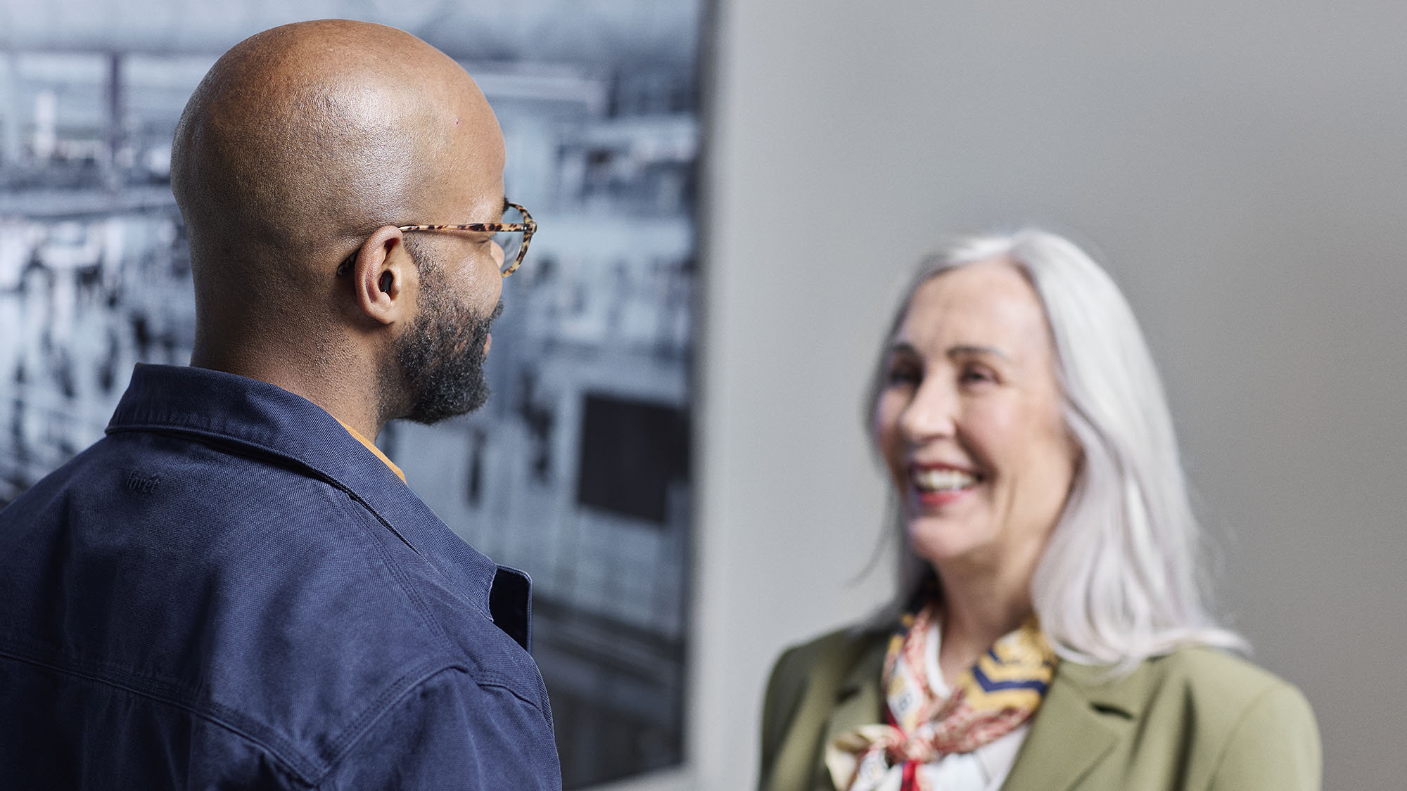 Man wearing Signia Insio Charge&Go CIC IX hearing aids while talking to lady