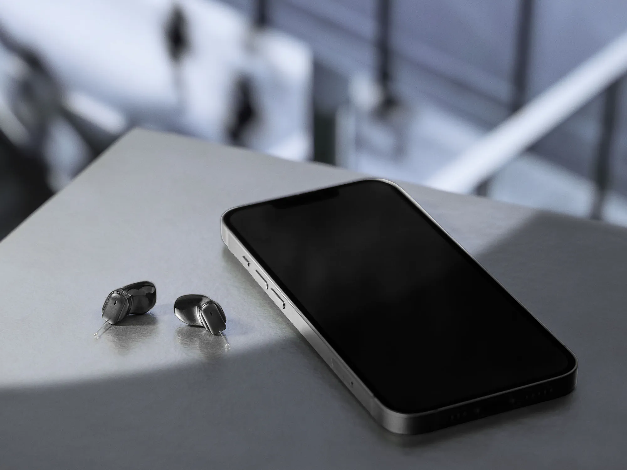 Signia Insio Charge&Go CIC IX comparing hearing aid small size to mobile phone