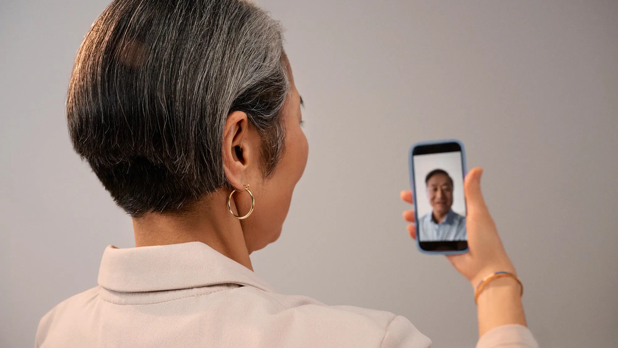 Signia Pure 補聴器を装着して、電話で Face Time をしている女性