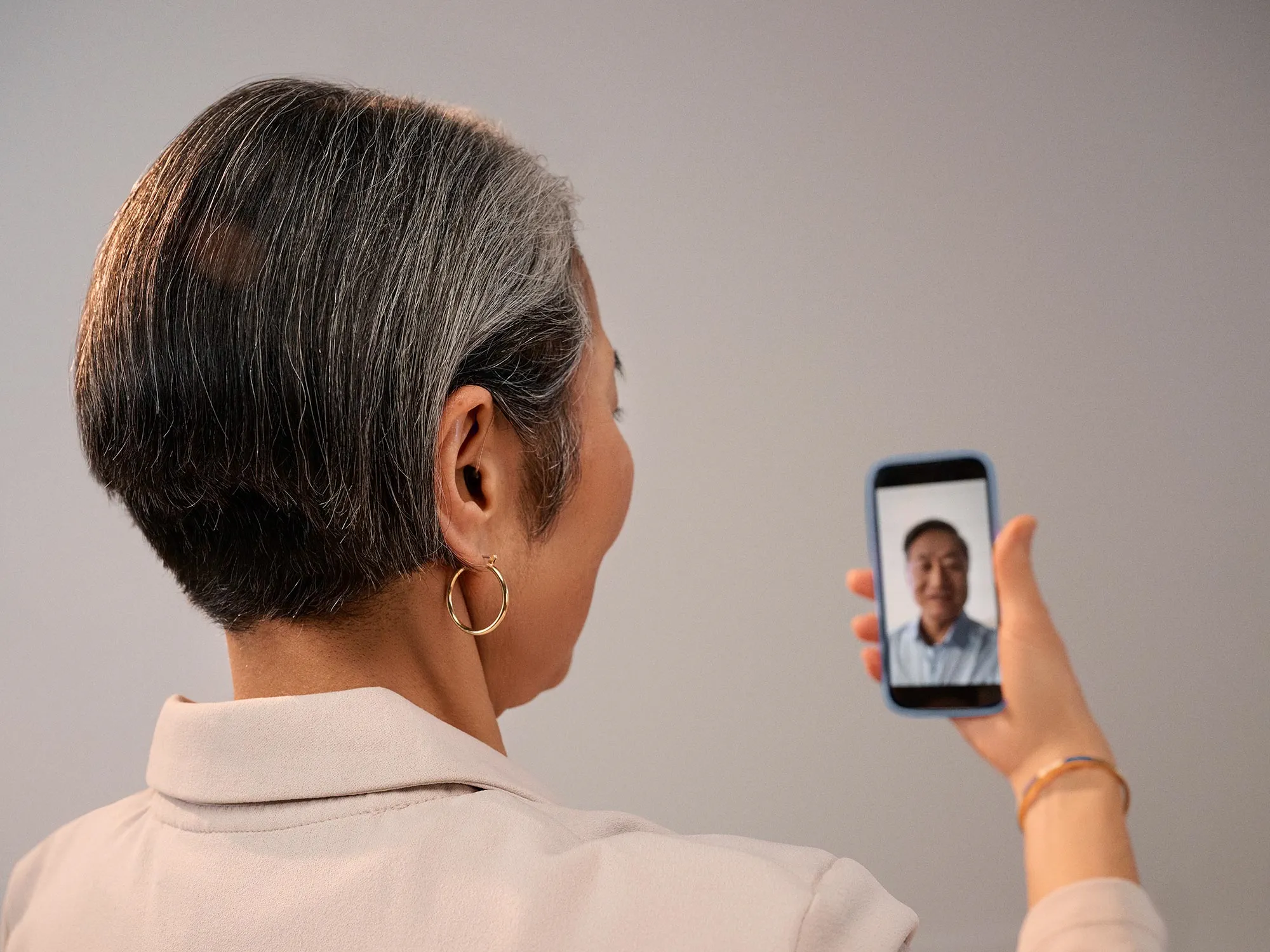 Signia Pure 補聴器を装着して、電話で Face Time をしている女性