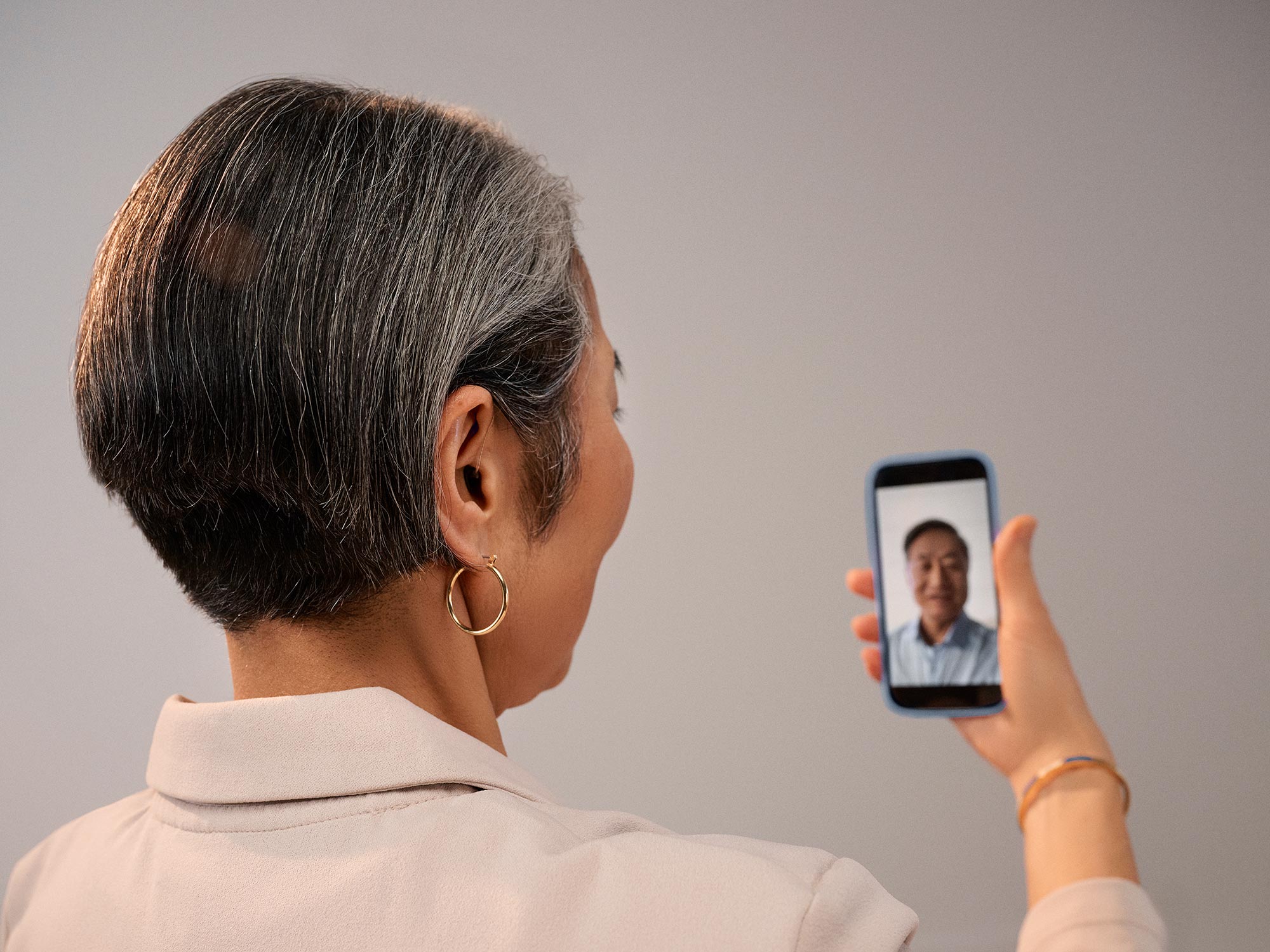 Signia Pure 補聴器を装着して、電話で Face Time をしている女性
