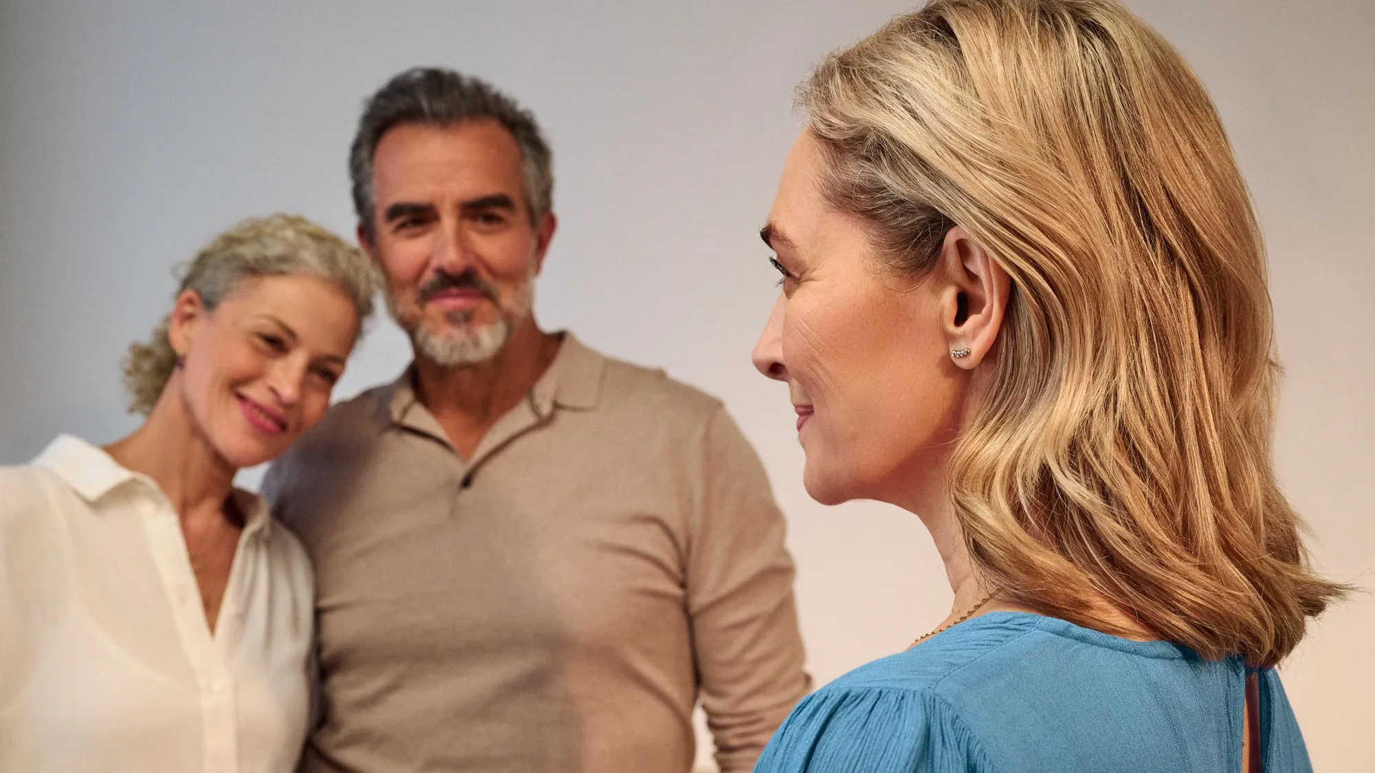 Woman wearing Signia Silk hearing aids while talking to friends