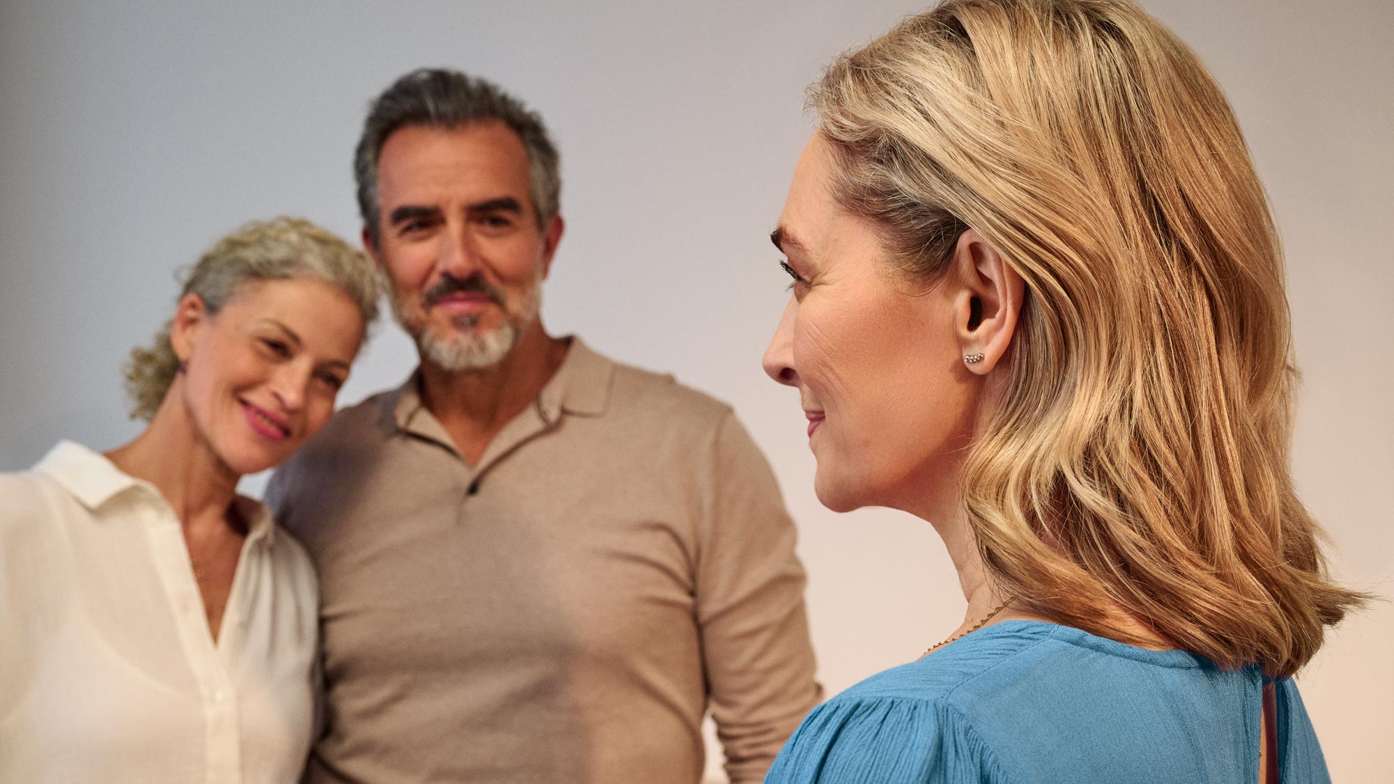 Woman wearing Signia Silk hearing aids while talking to friends