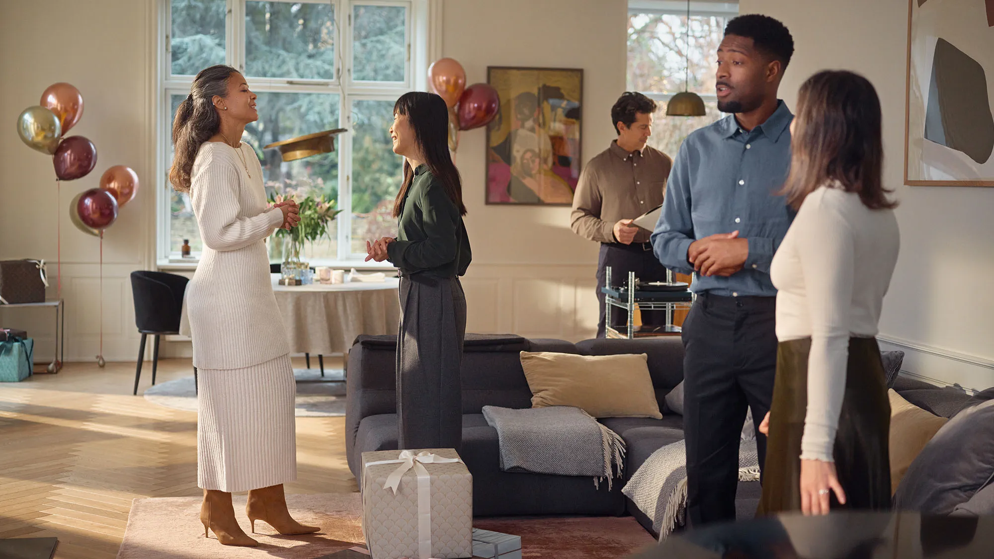 Woman wearing Widex Allure nearly invisible hearing aids at a party while talking to her friends being able to hear it all.