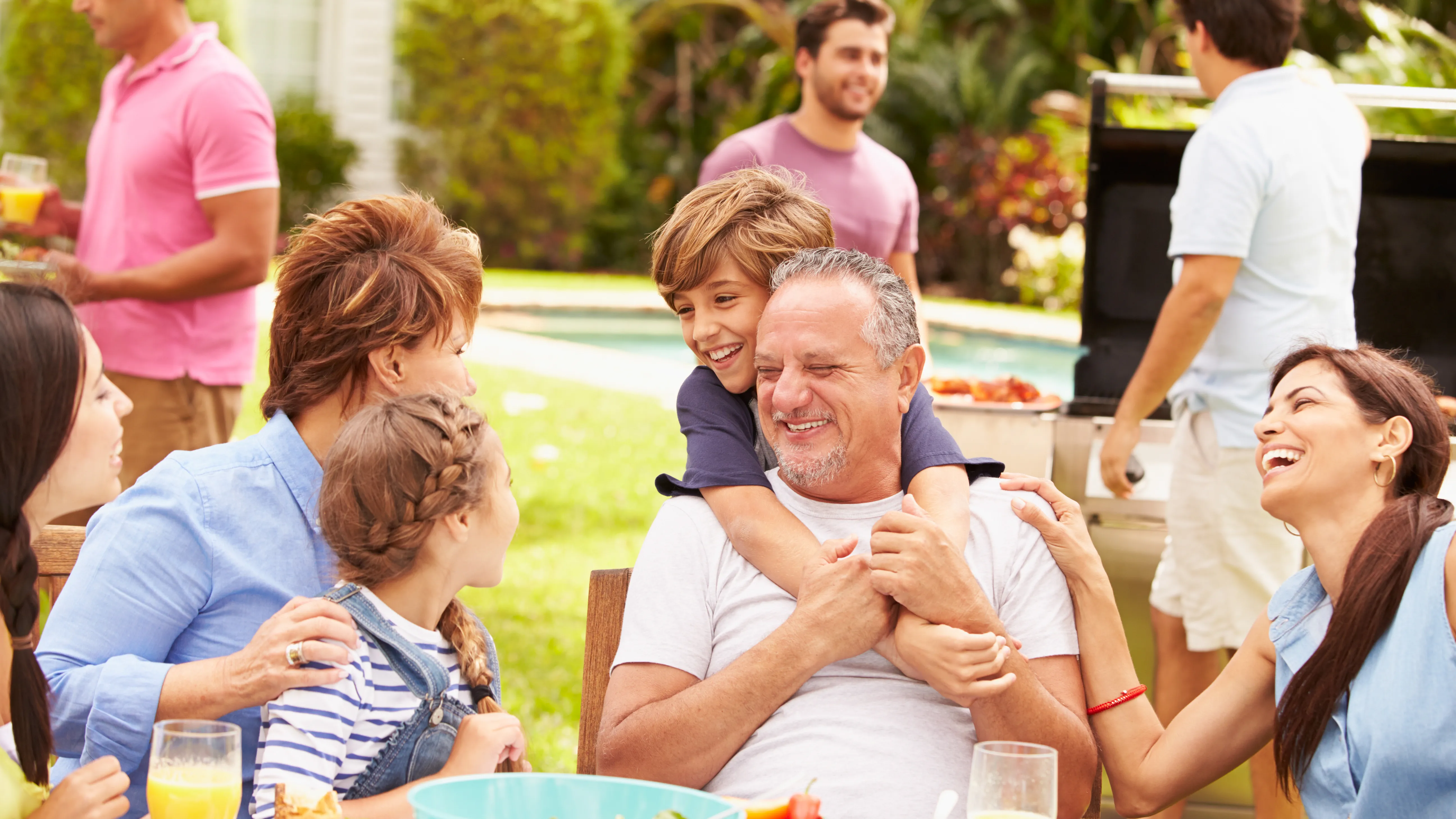 Family lunch in the garden, with a member struggling to hear amidst outdoor noises due to hearing loss