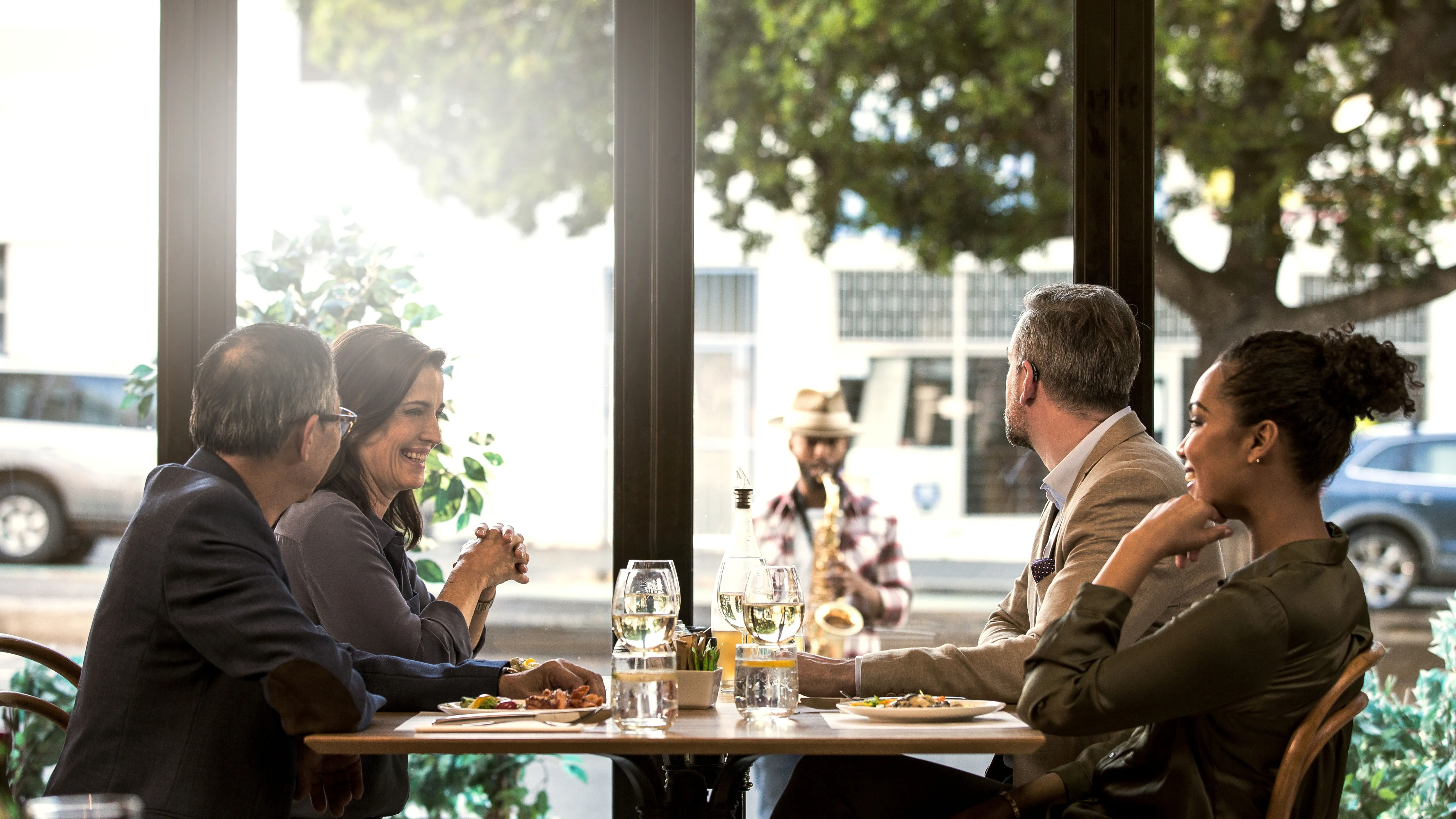 Friends at a café, where conversations are hard to follow due to hearing loss