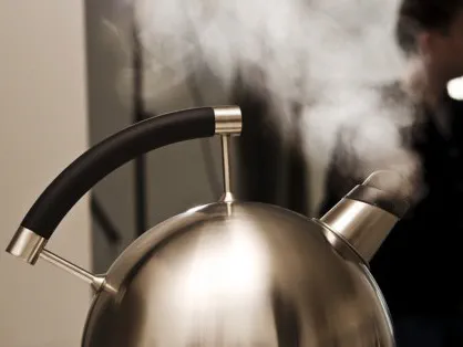 Tea kettle boiling over creating a high pitched sound risking hearing loss.