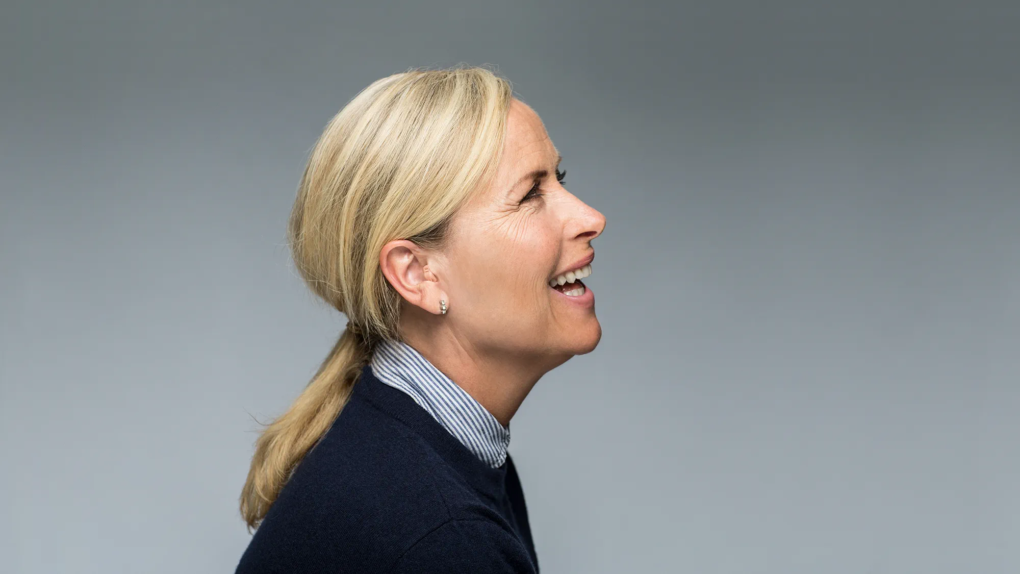 In the ear (ITE) hearing aid shown in the ear on woman.