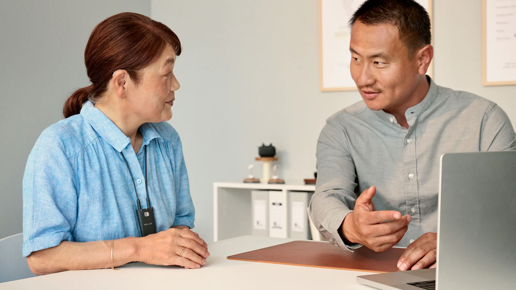 The audiologist programming a hearing aid for a customer at the appointment.