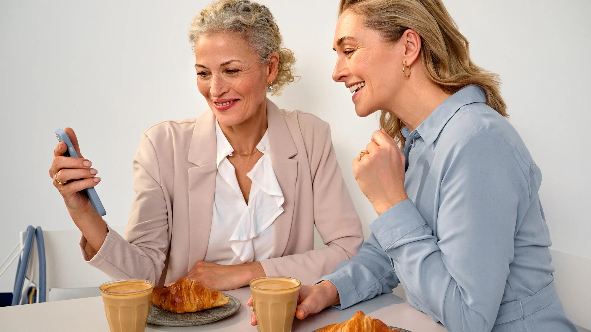 Friends sitting at a cafe, wearing hearing aids.