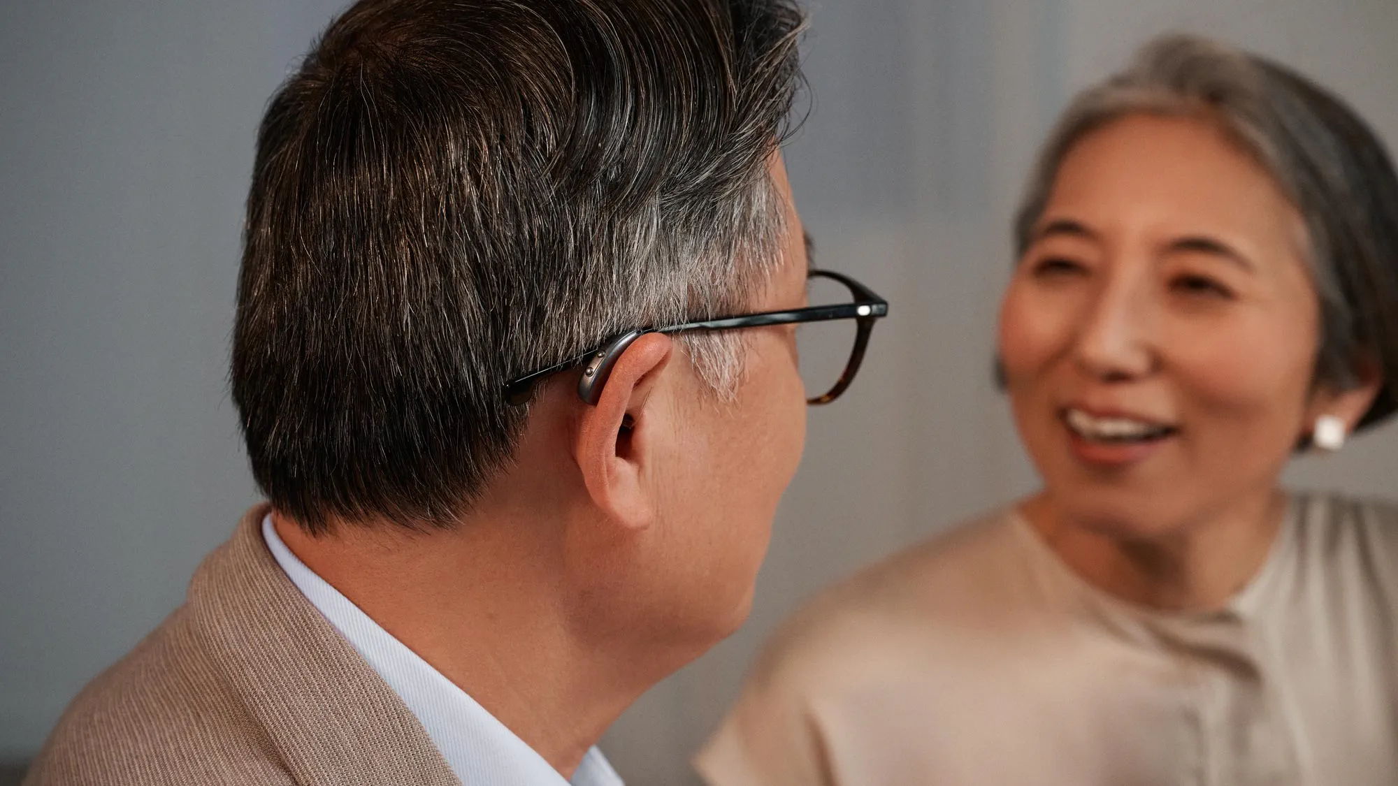 Couple chatting with man wearing Widex moment RIC hearing aids.