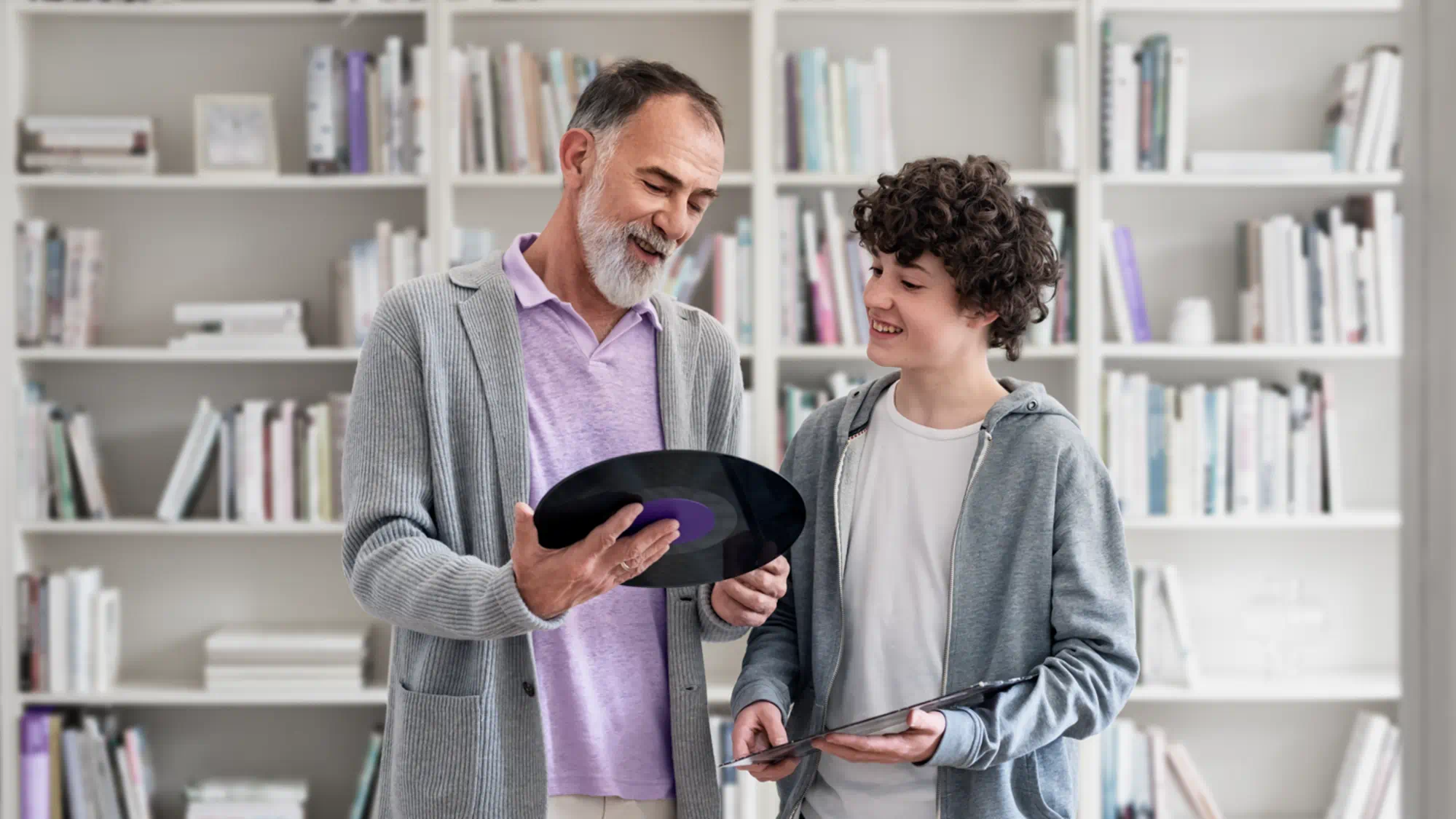 Avô a mostrar disco de vinil a neto