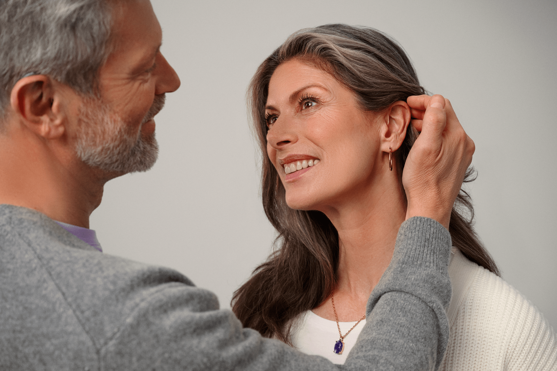 Um homem coloca o cabelo da mulher atrás da orelha
